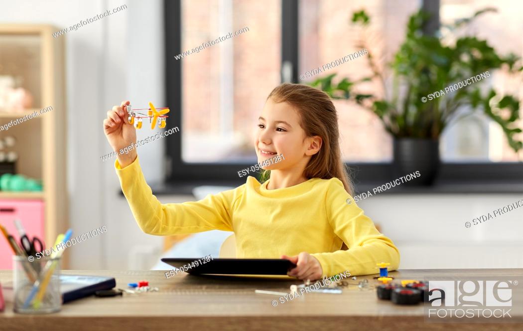 Stock Photo: girl with tablet pc and robotics kit at home.