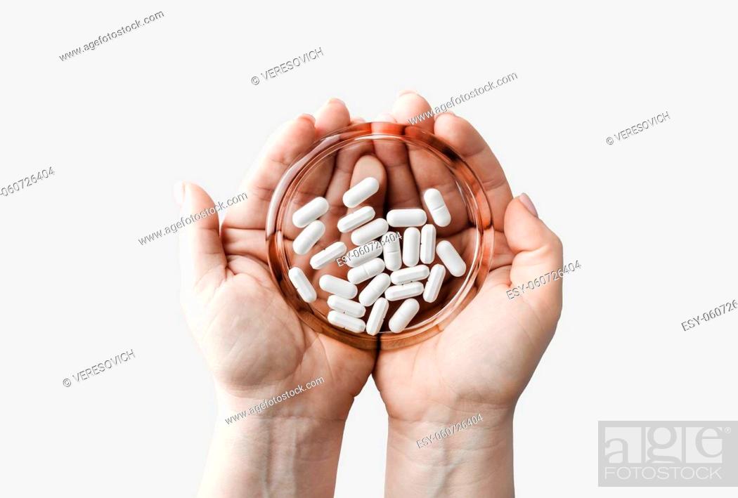 Imagen: Pills on glass saucer in female hands. Pharmaceutical medicaments.