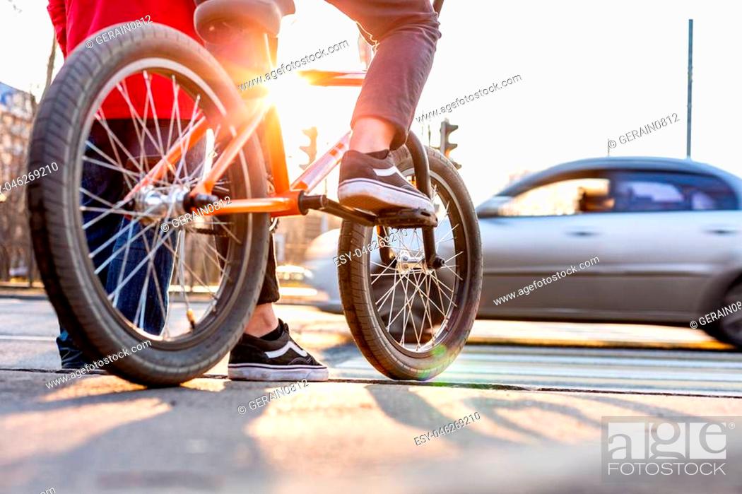 Stock Photo: Urban biking - teenage boy riding bike in city expects a pedestrian crossing.