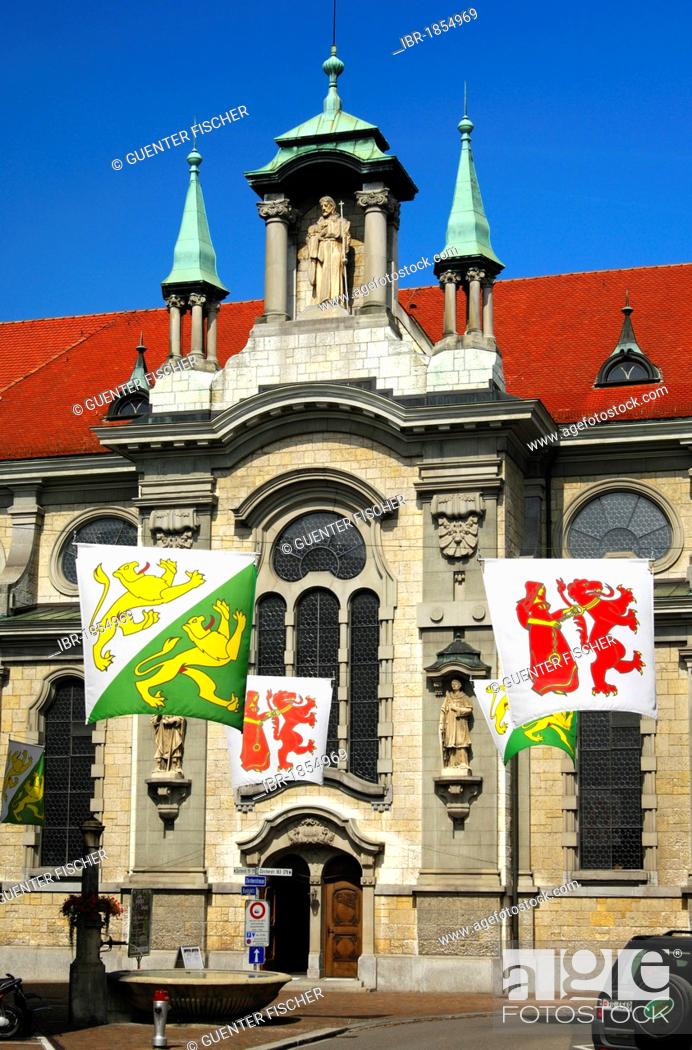 Stock Photo: Flags with the coat of arms of the canton of Thurgau and the Frauenfeld village in front of the Catholic church of St Nikolaus, Frauenfeld, Canton Thurgau.