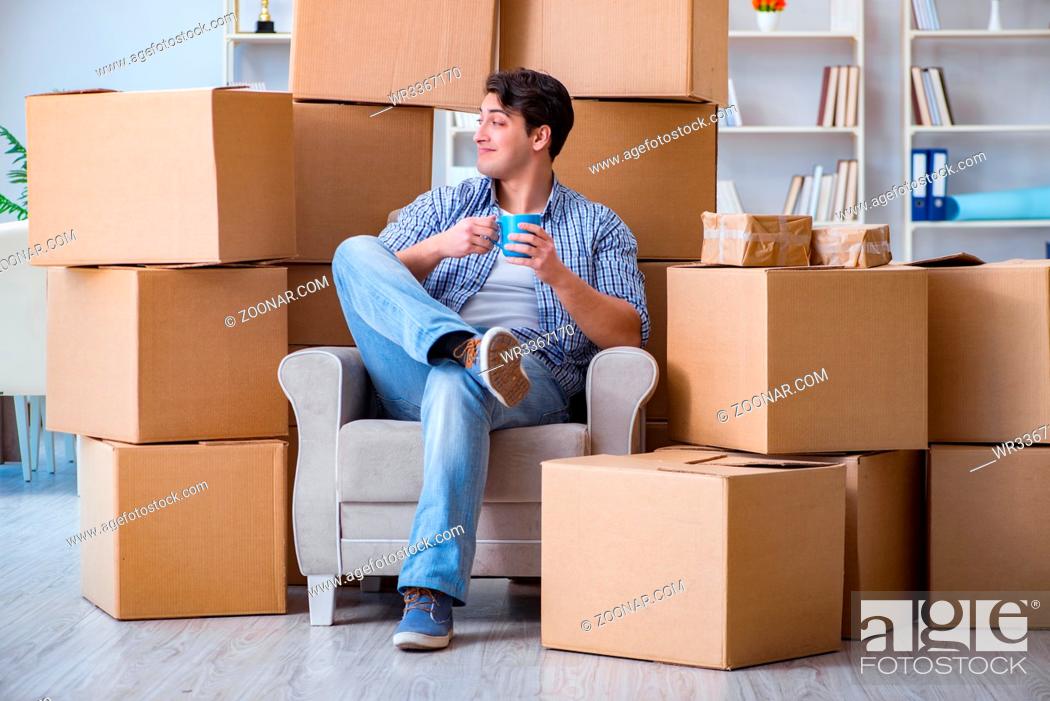 Imagen: Young man moving in to new house with boxes.