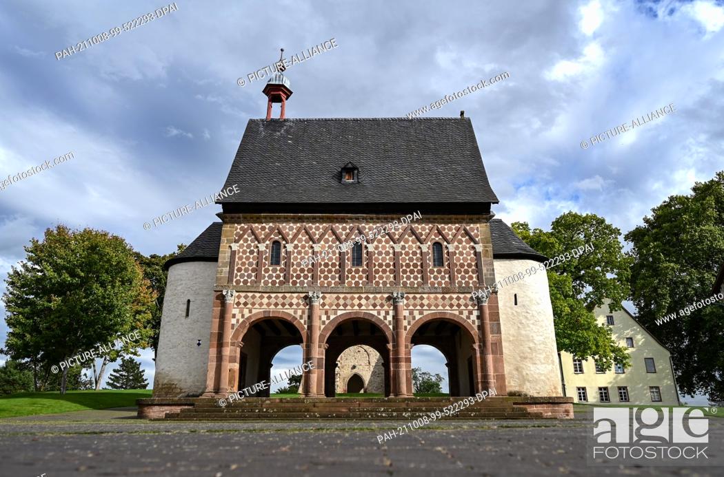 Stock Photo: 29 September 2021, Hessen, Lorsch: The so-called Gate Hall or King's Hall with its world-famous colourful sandstone façade rises in front of a park-like area.