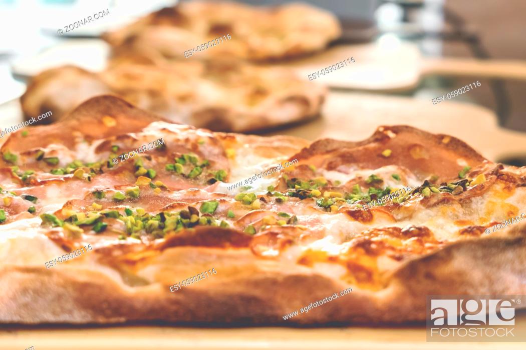 Stock Photo: Delicious gourmet pizza with ham, and pistachios.