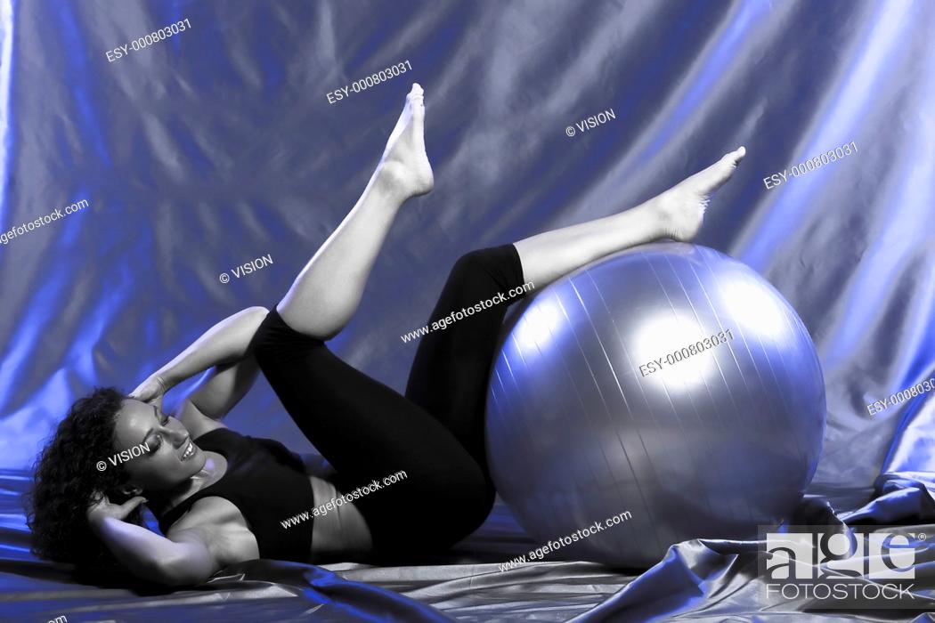 Stock Photo: young woman exercising swiss ball studio.