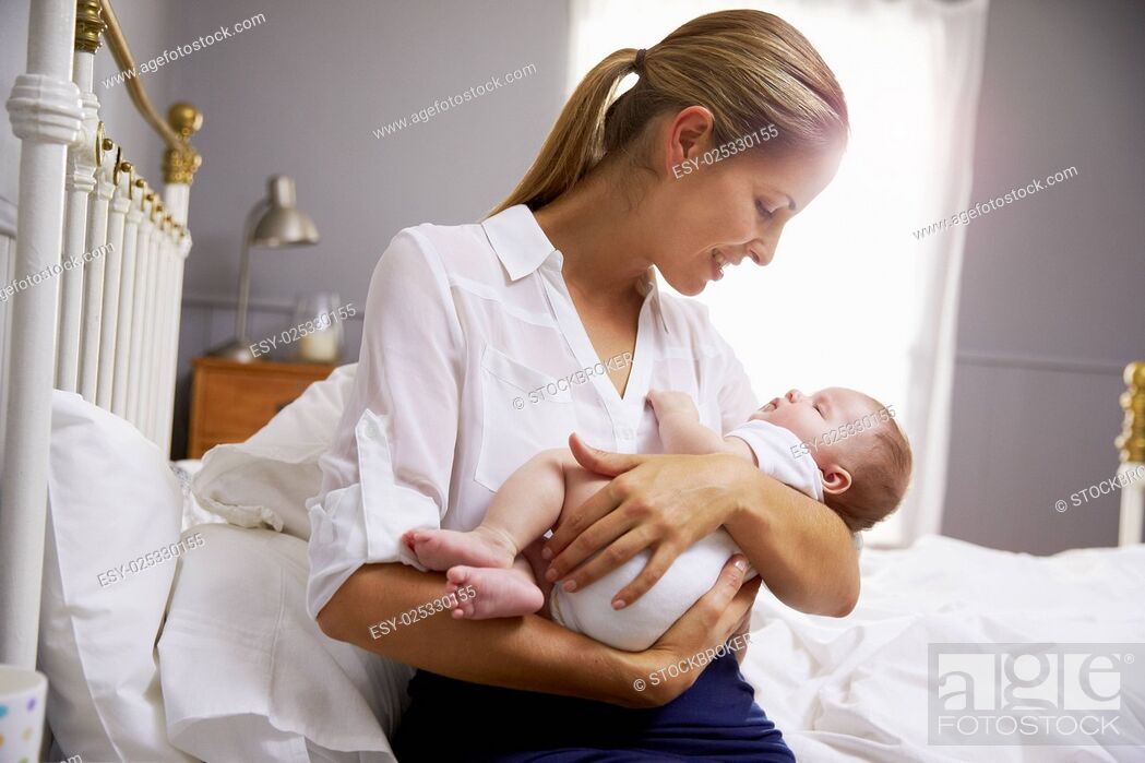 Stock Photo: Mother Dressed For Work Holding Baby In Bedroom.