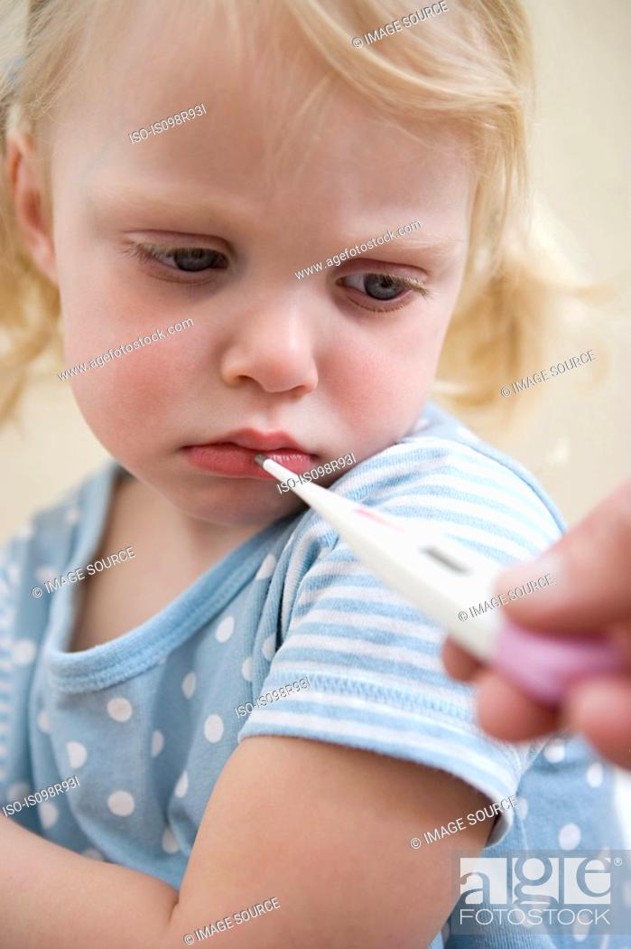 Stock Photo: Girl having her temperature taken.