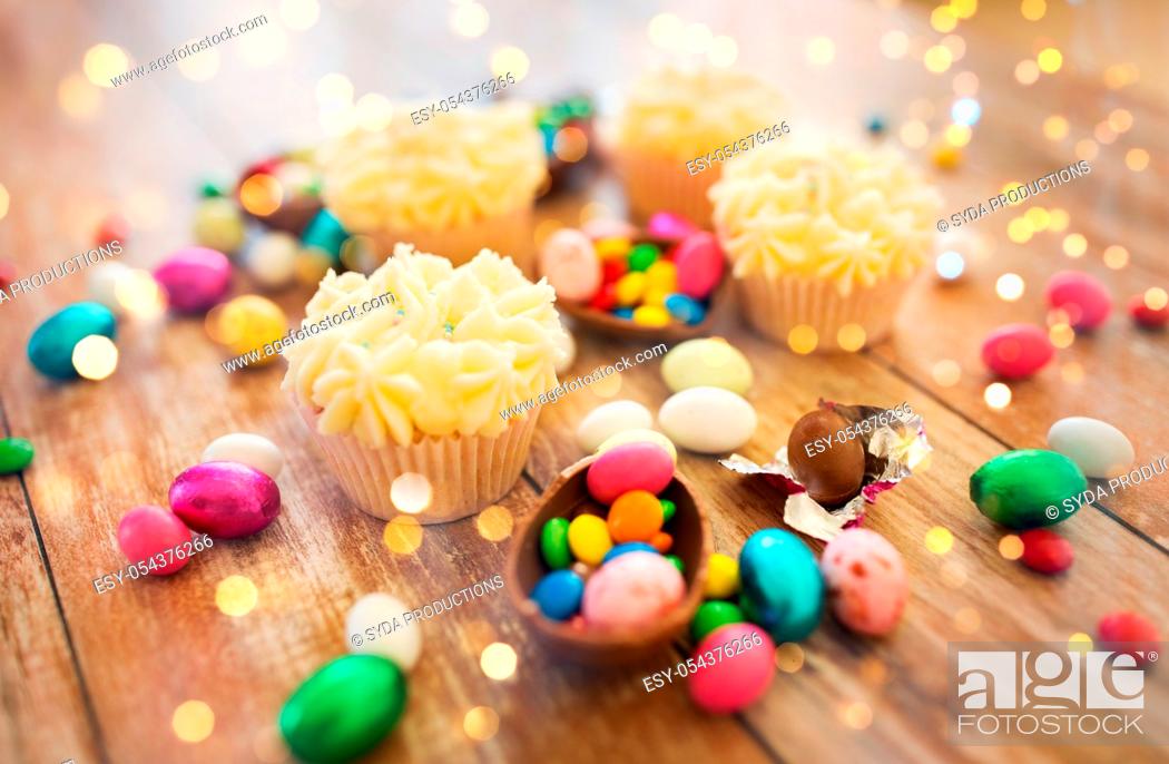 Imagen: cupcakes with chocolate eggs and candies on table.
