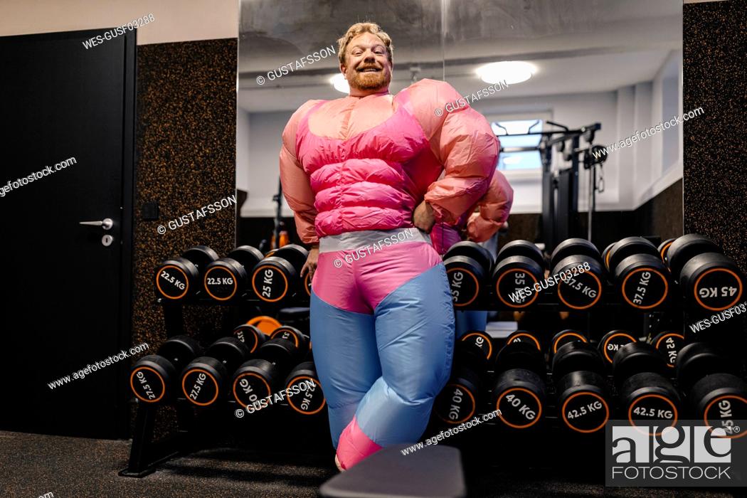 Stock Photo: Proud man wearing pink bodybuilder costume in gym.