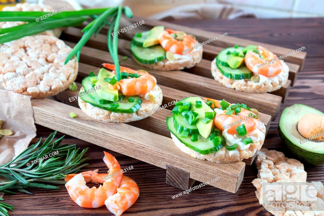 Stock Photo: Rice cakes with sliced avocado cucumber shrimp and cream cheese. Fresh parsley and rosemary. Vegetarian, vegan concept. Shallow depth of field.