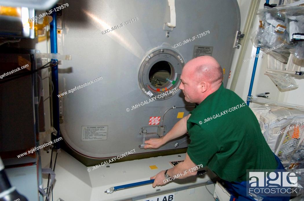 Stock Photo: European Space Agency astronaut Andre Kuipers, Expedition 30 flight engineer, closes a hatch in the International Space Station as crew members prepare to move.