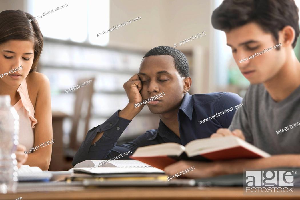 Stock Photo: Bored student studying with friends.