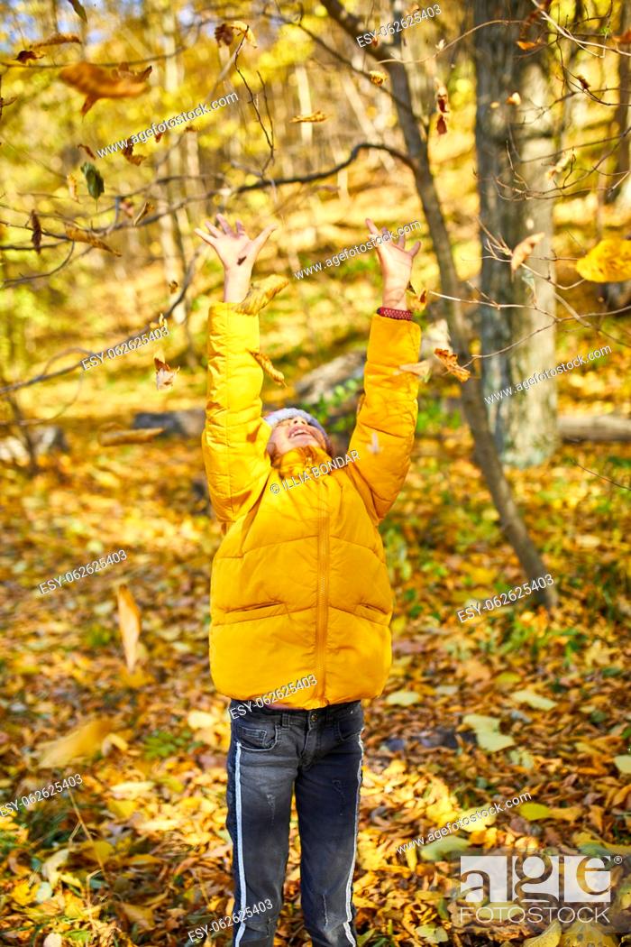 Stock Photo: Happy adorable child girl laughing and playing yellow fallen leaves in autumn outdoors, Happy moment.