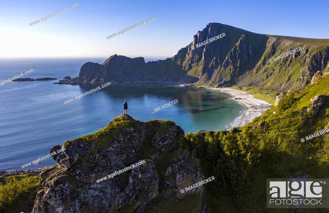 Stock Photo: Hiker standing at the precipice, cliffs, beach and sea, in the back peak of the mountain Måtinden, near Stave, Nordland, Norway, Europe.
