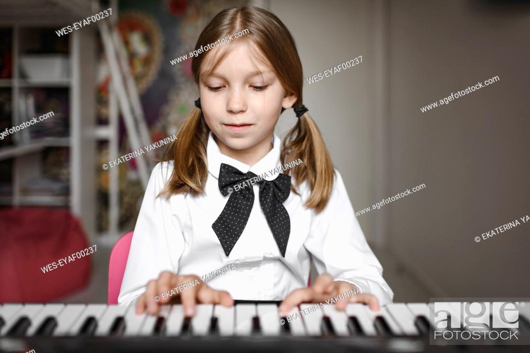 Stock Photo: Portrait of a girl playing synthesizer.
