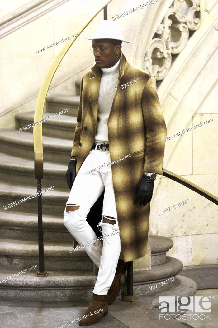 Imagen: stylish wealthy man wearing expensive clothes, standing on stairs, in city Munich, Germany.