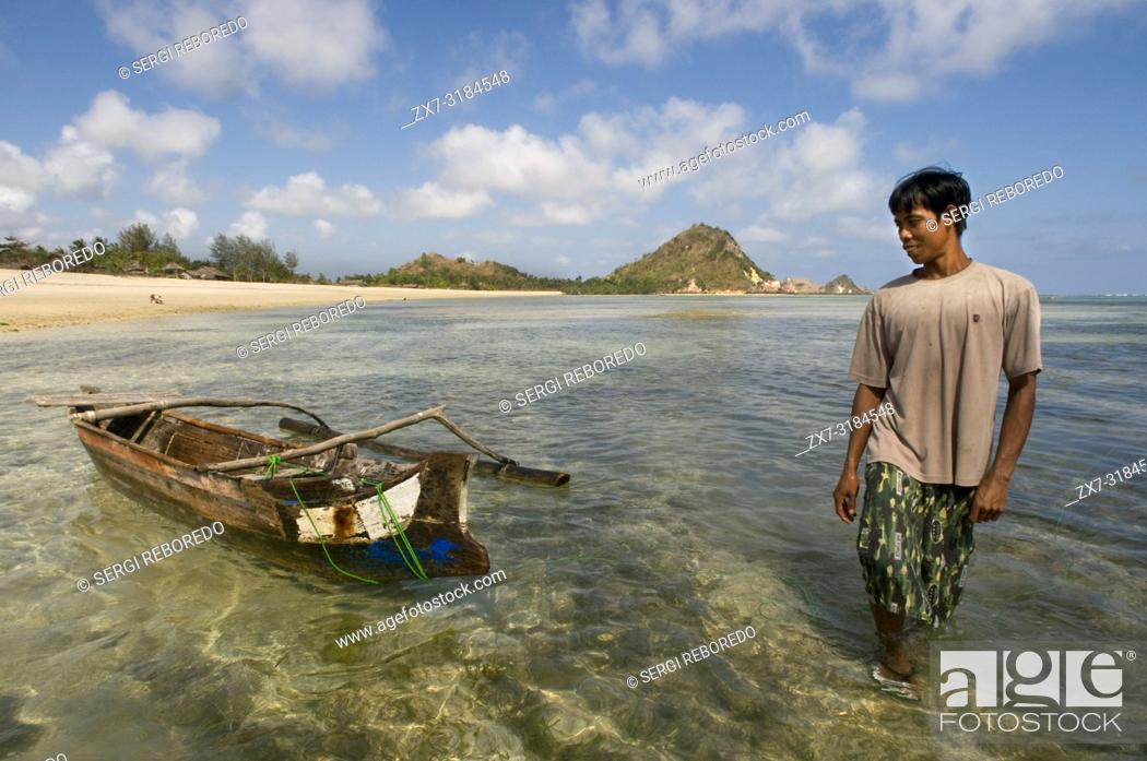 Stock Photo: A fisherman next to his boat on the shore of Kuta beach, a fishing village south of Lombok Indonesia.
