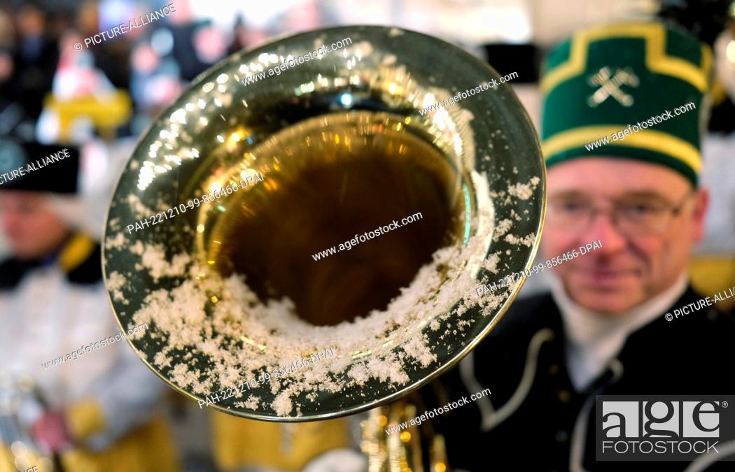 Stock Photo: 10 December 2022, Saxony, Oberwiesenthal: Snow lies in the funnel of a brass instrument by an actor of a miners' association.