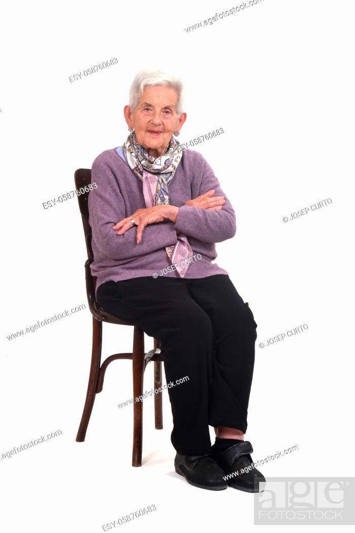 Stock Photo: side view of senior woman sitting on chair arms crossed on whte background.