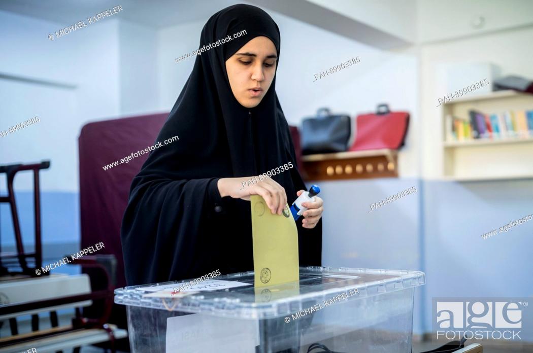 Stock Photo: A woman casts her vote into an ballot box at a polling station in Istambul, Turkey, 16 April 2017. Turkish citizens are voting on a constitutional amendment.
