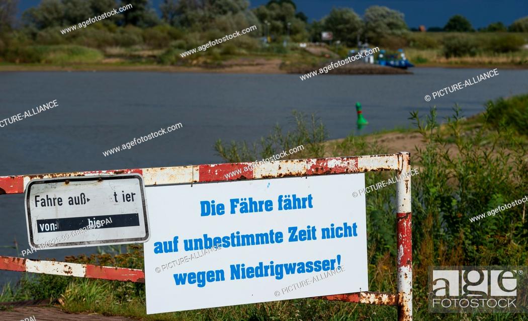 Stock Photo: 25 August 2018, Germany, Bleckede: ""The ferry does not run for an indefinite period of time because of low water"" is written on a sign at the jetty of the.