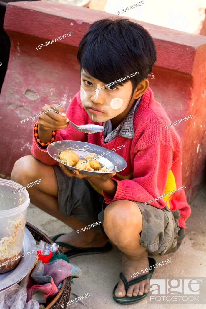 Stock Photo: Myanmar, Mandalay, Mingun. A young boy eats lunch in Mingun in Myanmar.