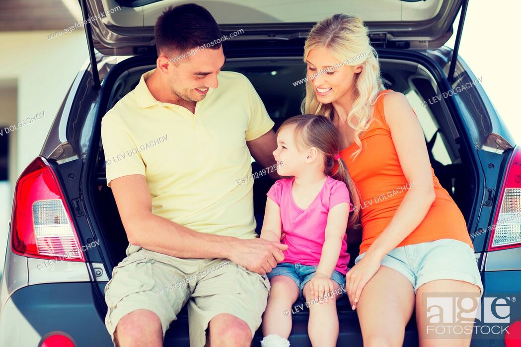Stock Photo: family , transport, leisure, road trip and people concept - happy man, woman and little girl sitting on trunk of hatchback car and talking outdoors.