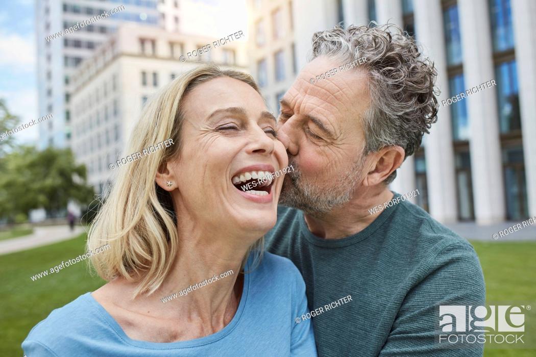 Stock Photo: Happy mature couple kissing in the city.