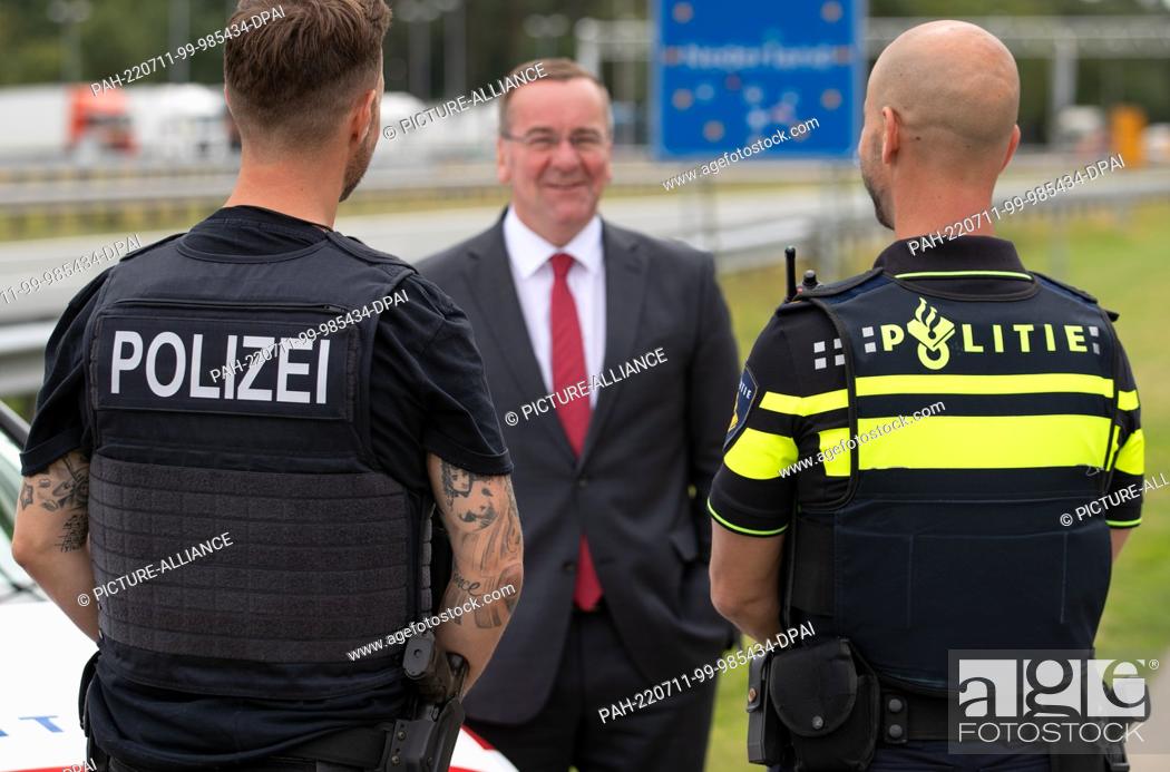 Stock Photo: 11 July 2022, Lower Saxony, Bad Bentheim: Lower Saxony's Interior Minister Boris Pistorius (SPD) talks with a German (l) and a Dutch (r) police officer from the.