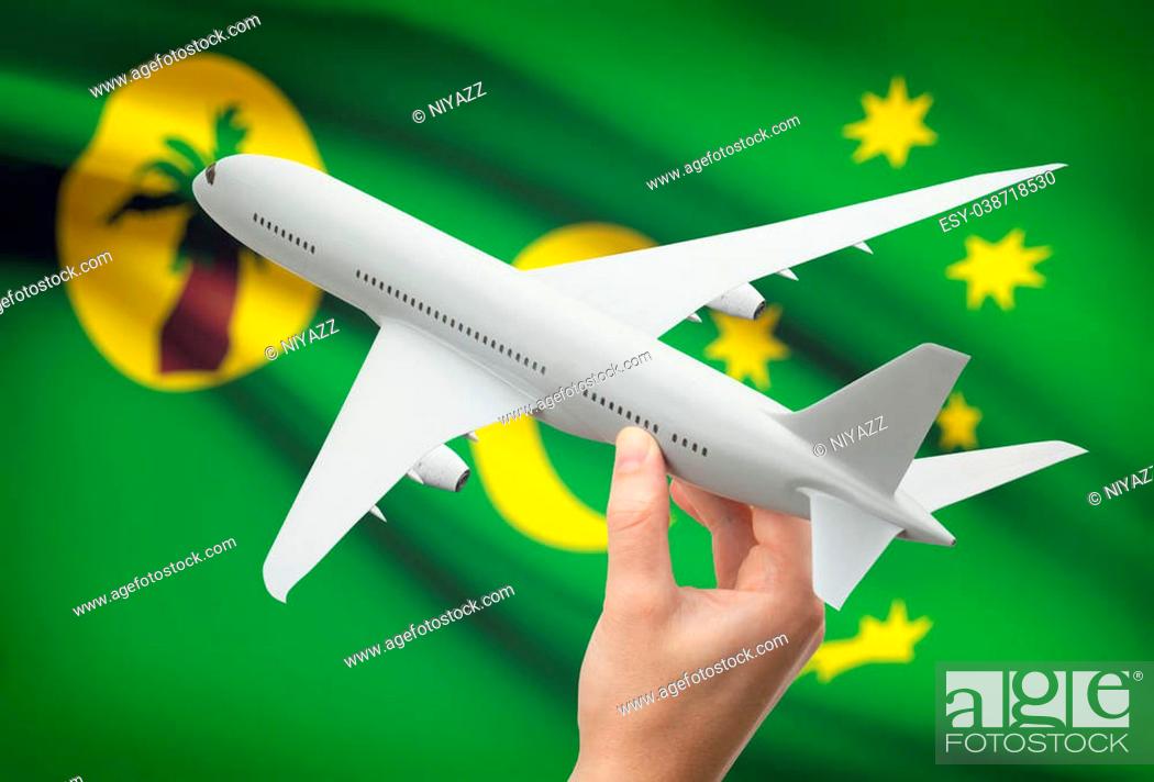 Stock Photo: Airplane in hand with national flag on background - Cocos (Keeling) Islands.