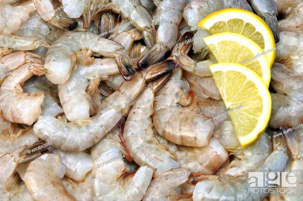 Stock Photo: Many Raw Green King Size Shrimps With Slices Of Yellow Lemon, Top View, Close Up, Isolated.
