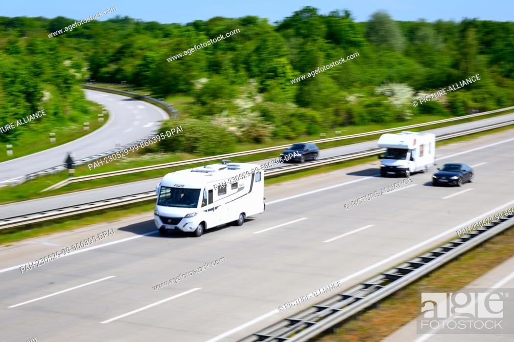 Stock Photo: 29 May 2023, Schleswig-Holstein, Hamberge: Motorhomes and cars drive on the A1 freeway at the Lübeck interchange. For the Whitsun weekend.