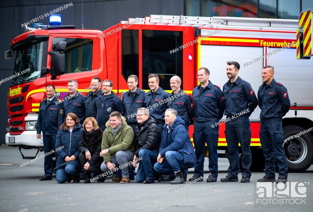 Stock Photo: 10 January 2019, North Rhine-Westphalia, Gelsenkirchen: The firefighters and producers of the television documentary ""Fire & Flame"" are standing in front of a.