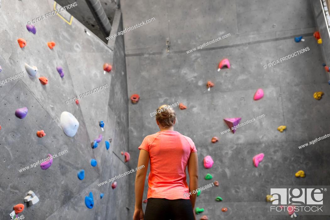 Stock Photo: young woman at indoor climbing wall in gym.