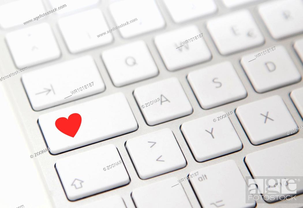 Stock Photo: White computer keyboard with red heart button.