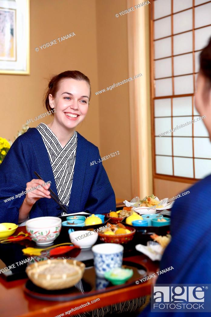 Stock Photo: Caucasian woman wearing yukata eating at traditional ryokan, Tokyo, Japan.