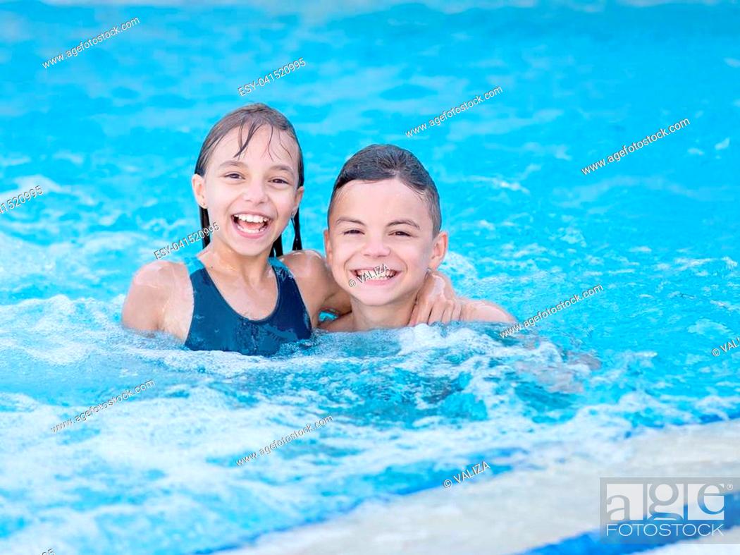 Stock Photo: Smiling beautiful children in the swimming pool at aquapark. Happy teen boy and girl - brother and sister having fun together enjoyable time on vacation.