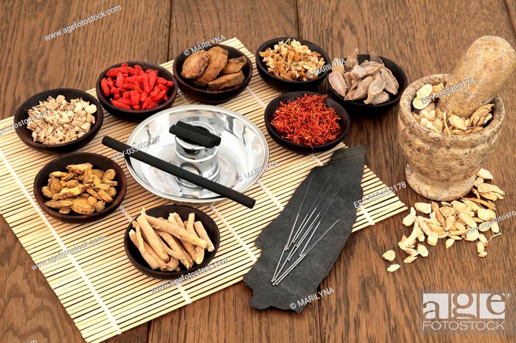 Stock Photo: Acupuncture needles, moxa sticks, traditional chinese herbs for herbal medicine and mortar with pestle over bamboo and old oak background.