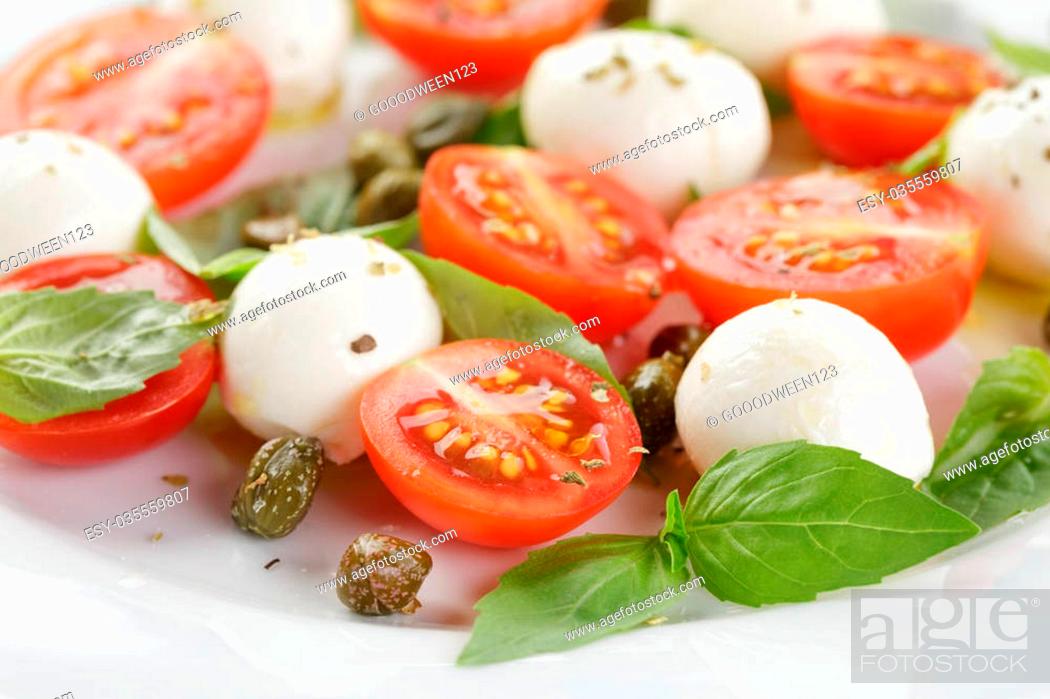 Stock Photo: caprese salad with mini mozzarella balls and tomatoes, close up photo.