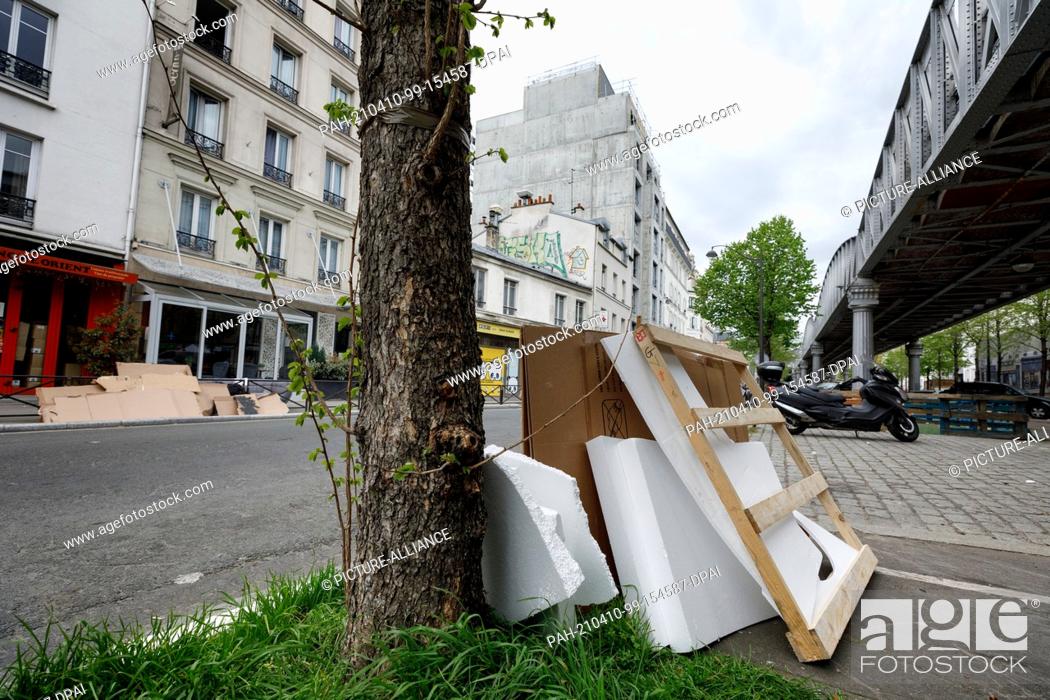 Stock Photo: 09 April 2021, France, Paris: Garbage stands under a subway bridge in the 15th district of Paris. Bulky waste on the sidewalk, overflowing garbage cans.
