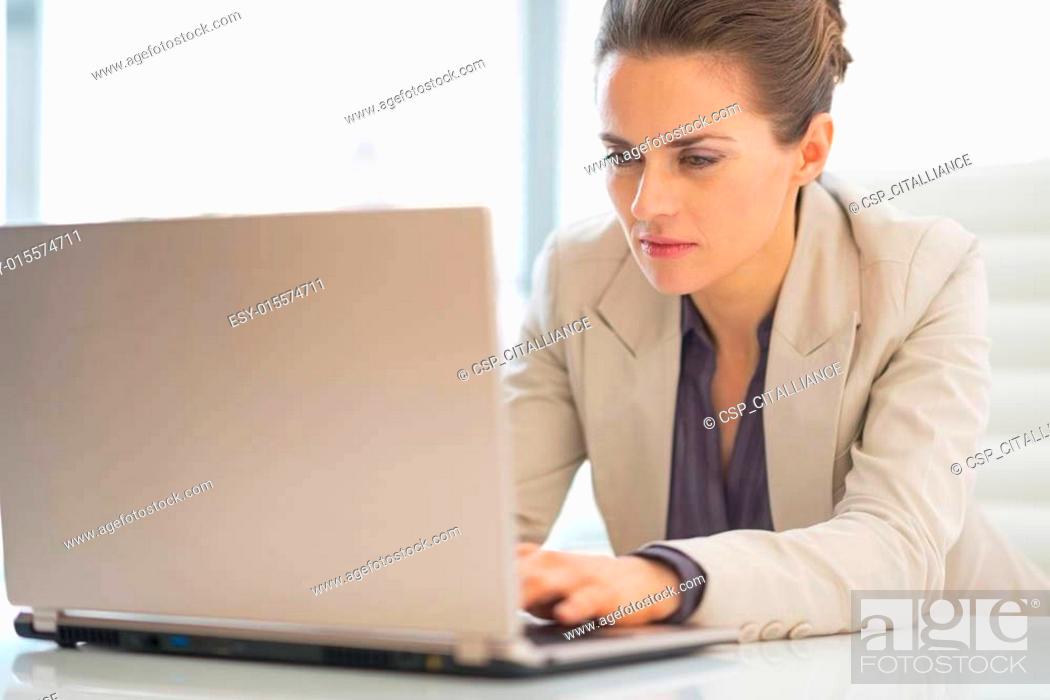 Stock Photo: Business woman working on laptop in office.