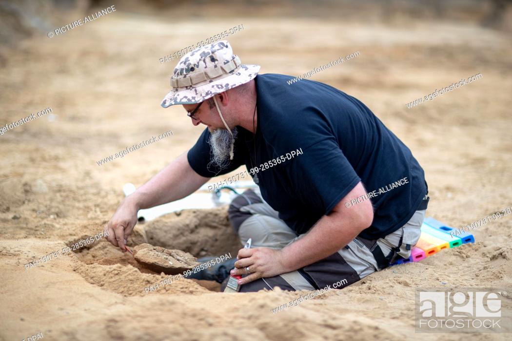 Stock Photo: 31 July 2019, Mecklenburg-Western Pomerania, Pinnow: Fabian Möller, excavation assistant at the State Office for Archaeology in Mecklenburg-Vorpommern.