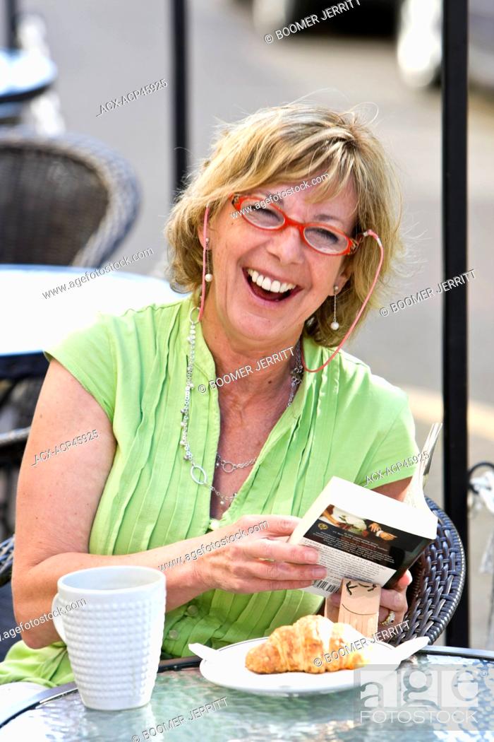 Stock Photo: A middle aged woman shares a laugh while dining at an outdoor patio eatery in Nanaimo's old city quarter, Nanaimo, Central Vancouver Island, British Columbia.