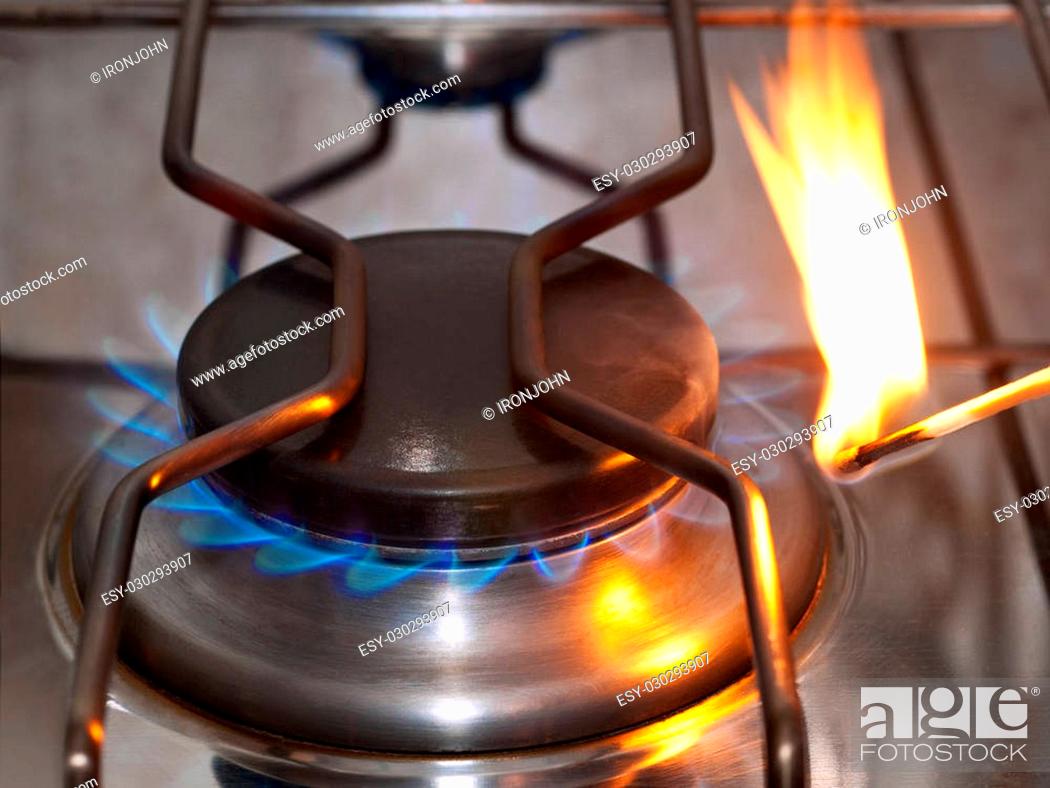 Stock Photo: Gas cooker is lit with a match.
