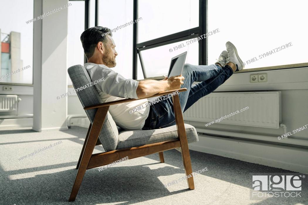 Stock Photo: Mature businessman using laptop in empty office.