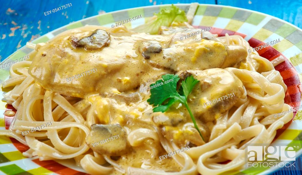 Stock Photo: Creamy Tuscan Garlic Chicken - juicy crusted chicken served over noodles with a delicious creamy tuscan garlic sauce.