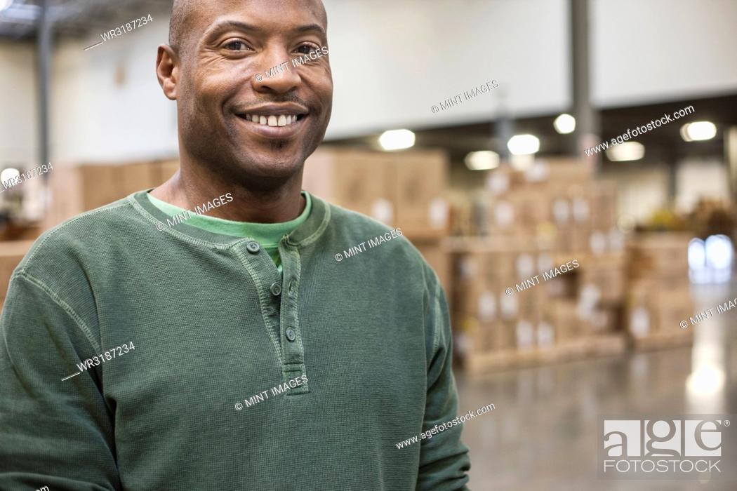 Stock Photo: Portrait of an African American warehouse worker in a large distribution warehouse.