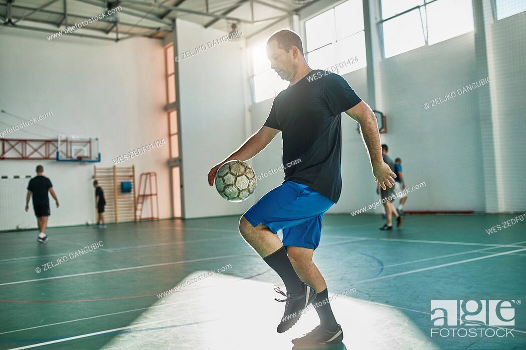 Stock Photo: Indoor soccer player balancing the ball.