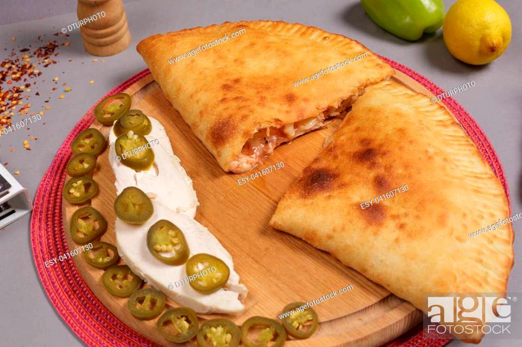 Photo de stock: Italian pizza calzone with mushrooms, spinach and cheese on a wooden surface, rustic style.