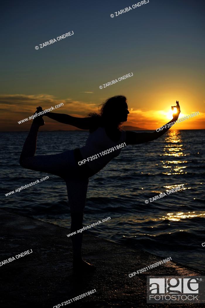Photo de stock: practising yoga at the sea beach (CTK Photo/Ondrej Zaruba).