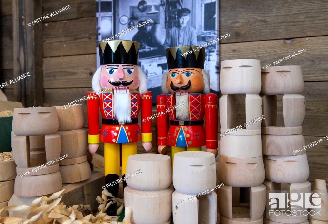 Stock Photo: 25 October 2021, Saxony, Seiffen: Two examples of the ""Red King"" nutcracker stand in the workshop of wooden toy maker Markus Füchtner in Seiffen.